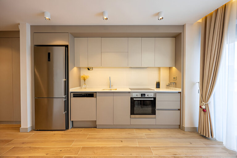 Modern minimalist Kitchen Cabinets Toronto design in a compact condo kitchen with white cabinets, built-in appliances, and under-cabinet lighting.