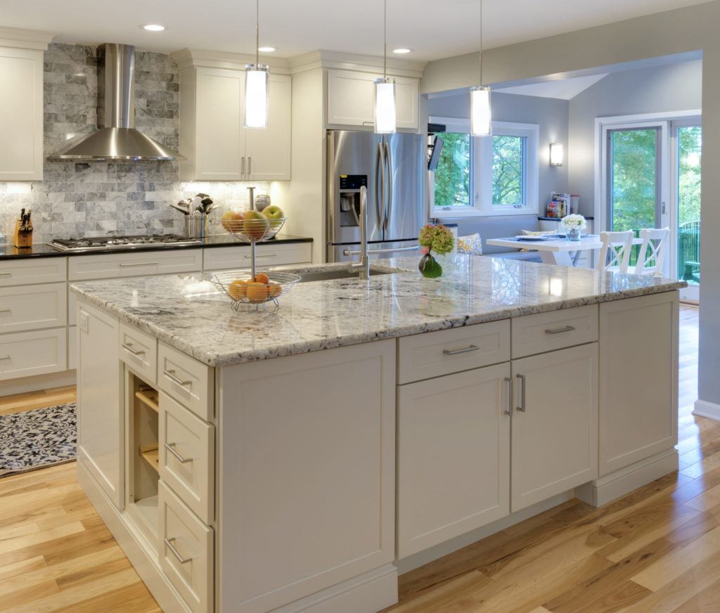 Modern white kitchen cabinet design with granite island countertop in a bright Canadian kitchen interior