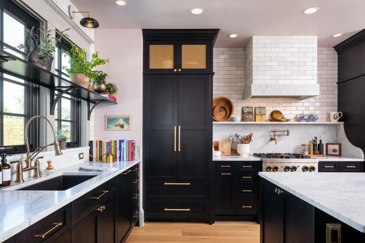 Modern kitchen with black shaker RTA kitchen cabinets, brass hardware, and marble countertops.