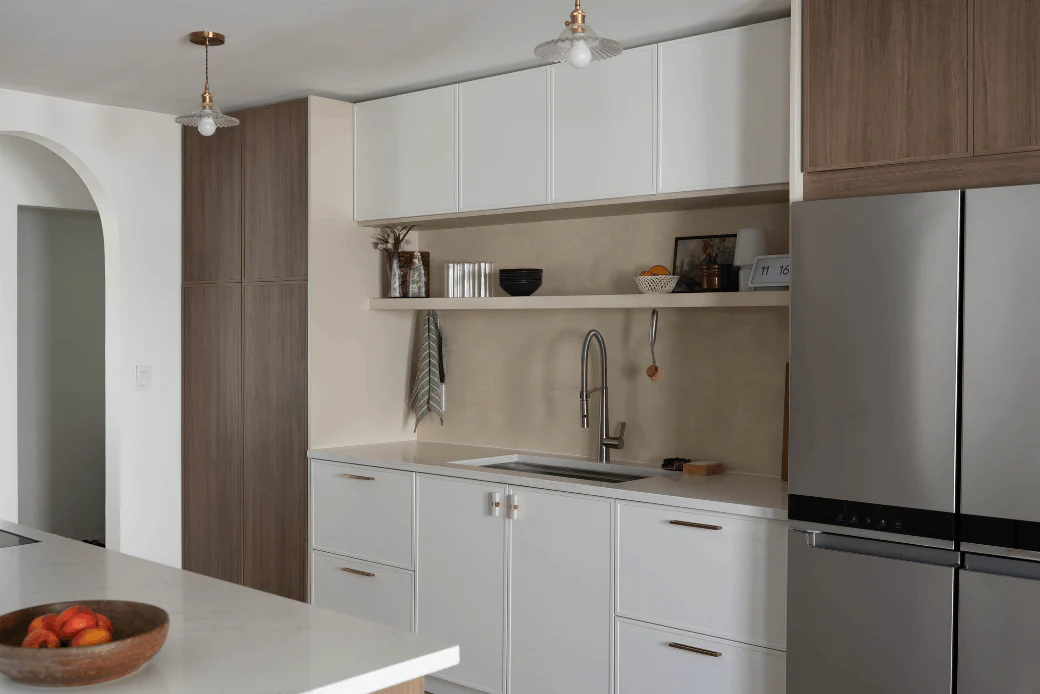 Kitchen cabinets Mississauga in a modern minimalist kitchen with white flat-panel cabinets and wood pantry units