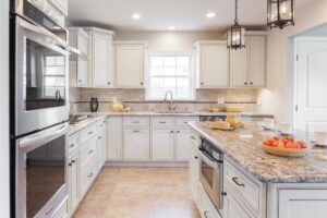 Kitchen Cabinets Oakville in a bright modern kitchen with white shaker cabinets, granite countertops, stainless steel appliances, and a large center island