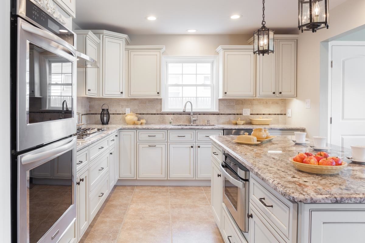 Kitchen Cabinets Oakville in a bright modern kitchen with white shaker cabinets, granite countertops, stainless steel appliances, and a large center island