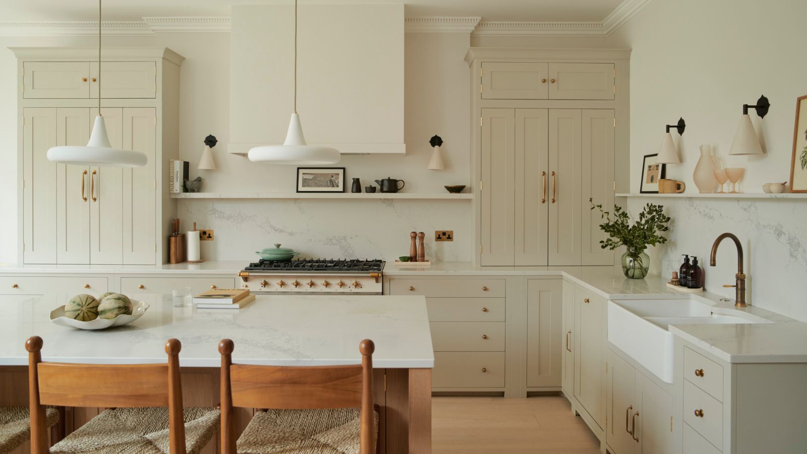 Kitchen Cabinets Milton in a bright modern kitchen with cream shaker cabinets, brass hardware, quartz countertops, and a large island
