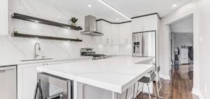 Modern white Kitchen Cabinets Markham design with waterfall island, stainless steel appliances, open floating shelves, and bright luxury interior.