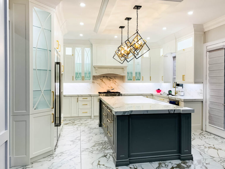 Luxury white kitchen cabinets Mississauga with marble countertops, black island, and modern pendant lighting in an elegant contemporary kitchen.