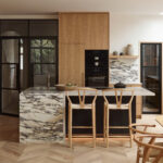 Modern Kitchen Cabinets Richmond Hill design featuring warm wood cabinetry, a marble waterfall island, sleek built-in appliances, and a bright minimalist layout.