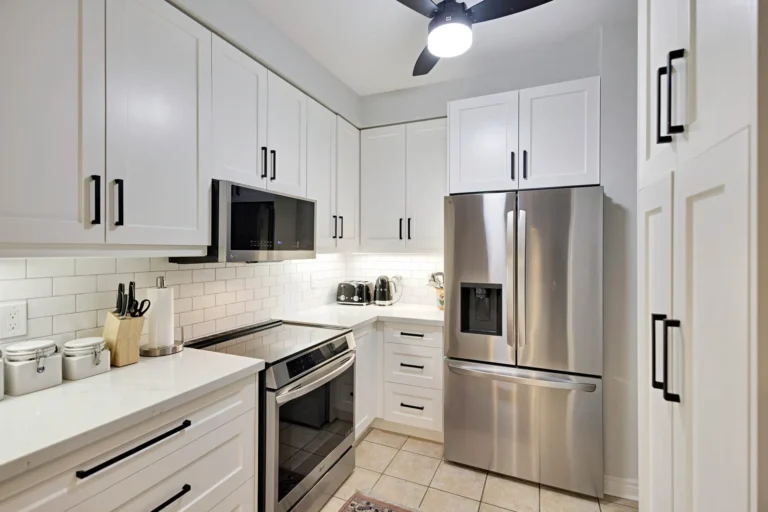 Modern Kitchen Cabinets Oakville design featuring white shaker cabinets, black hardware, quartz countertops, subway tile backsplash, and stainless steel appliances.