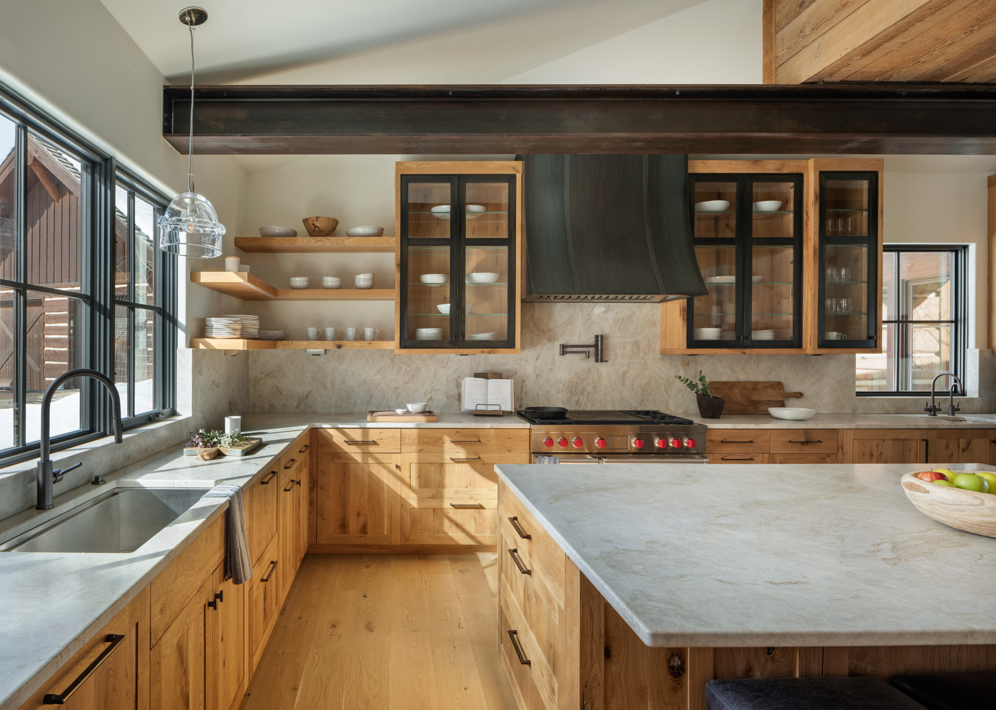 Kitchen Cabinets Burlington in a bright modern farmhouse kitchen with natural wood cabinetry, black-framed glass upper cabinets, open shelving, and a large stone island.