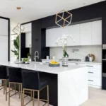 Modern black and white kitchen cabinets in Hamilton with a large waterfall island, built-in ovens, and minimalist design.