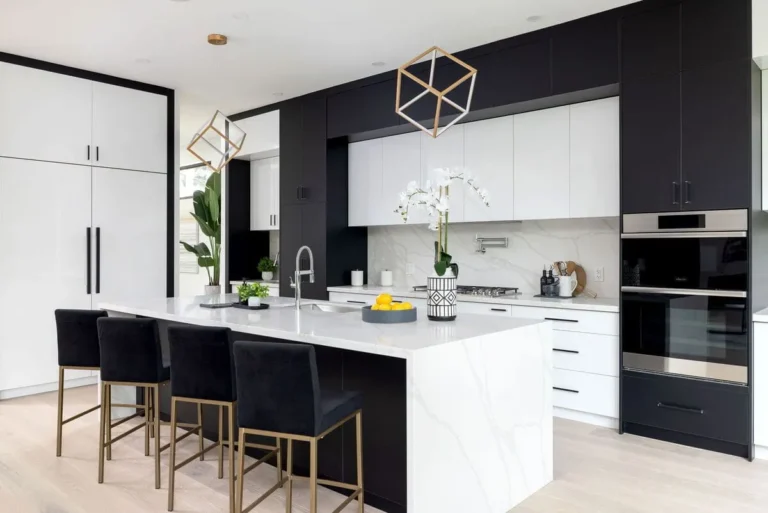 Modern black and white kitchen cabinets in Hamilton with a large waterfall island, built-in ovens, and minimalist design.