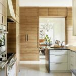 Premium kitchen cabinets with natural wood wall panels and white island drawers