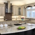 Transitional kitchen cabinets in Mississauga with cream raised-panel doors, granite island, and mosaic tile backsplash.