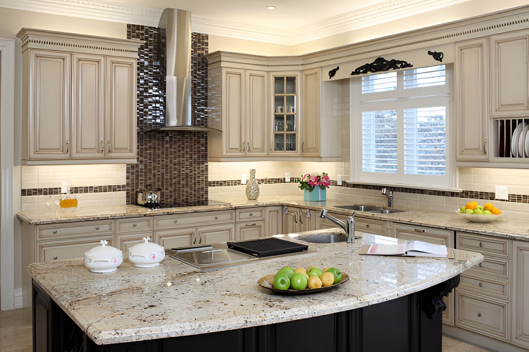 Transitional kitchen cabinets in Mississauga with cream raised-panel doors, granite island, and mosaic tile backsplash.