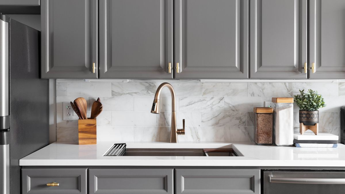 modern gray rta kitchen cabinets with marble backsplash and gold hardware