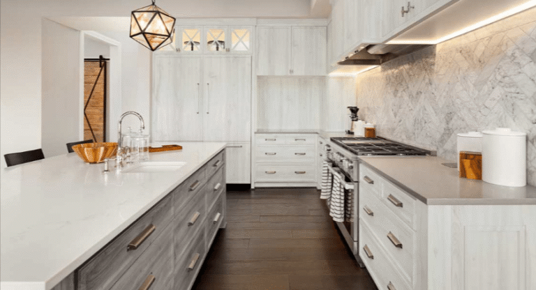 Premium kitchen cabinets Mississauga and Toronto – dark navy shaker cabinets with brass hardware and white subway tile backsplash