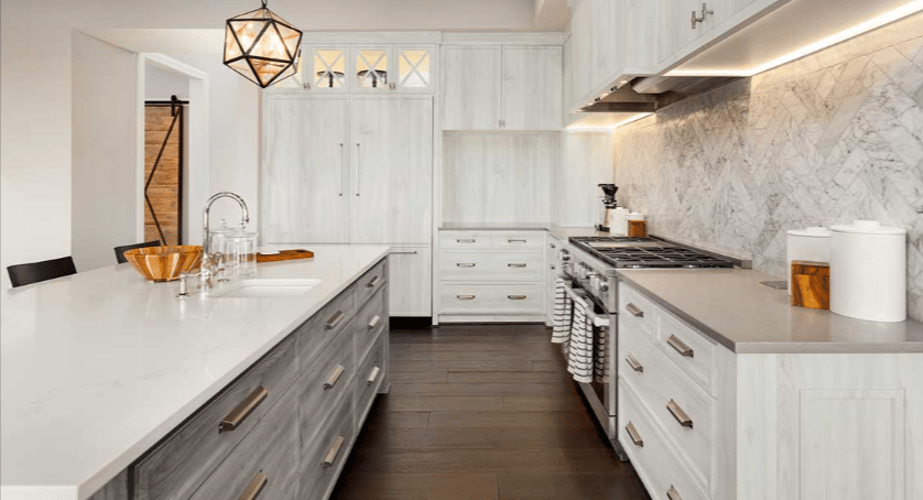 Premium kitchen cabinets Mississauga and Toronto – dark navy shaker cabinets with brass hardware and white subway tile backsplash