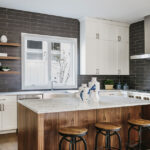 Modern white shaker kitchen cabinets Mississauga with charcoal subway tile backsplash and walnut waterfall island.