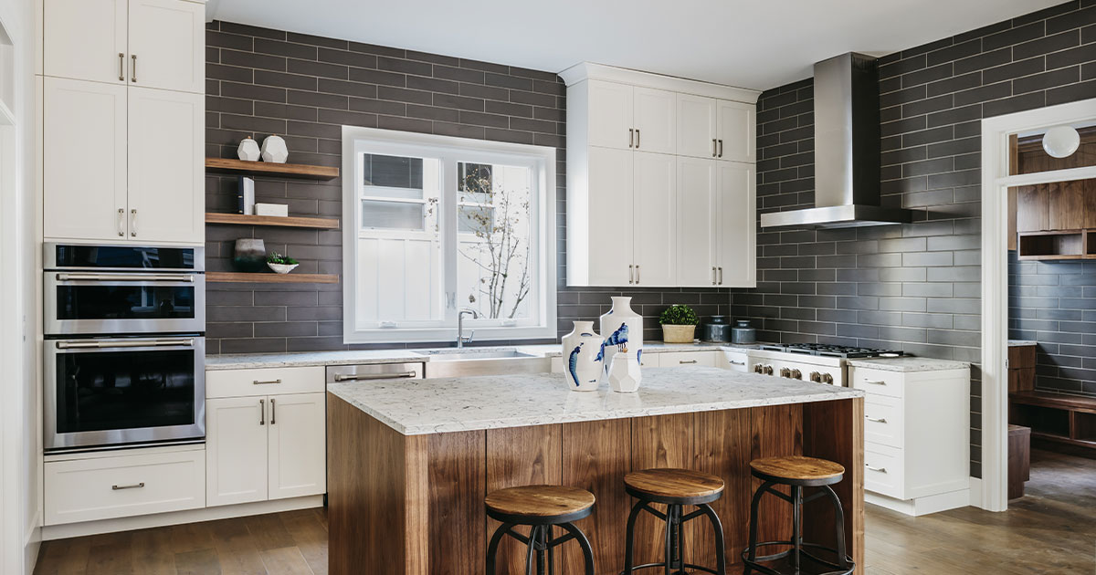 Modern white shaker kitchen cabinets Mississauga with charcoal subway tile backsplash and walnut waterfall island.