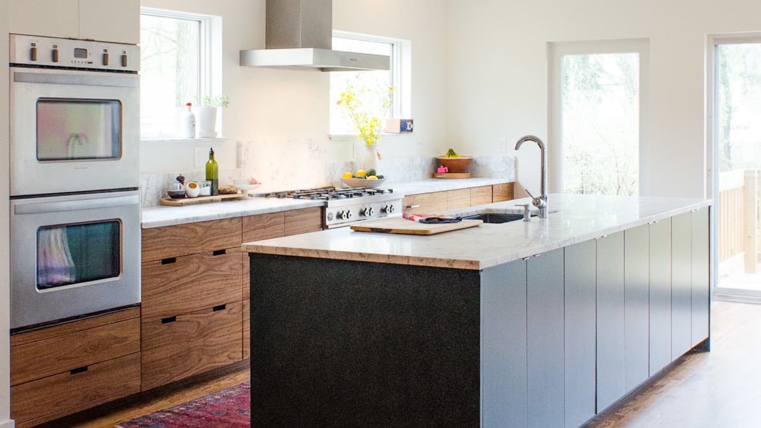 Modern IKEA kitchen cabinets with wood base cabinets and a large white island