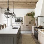 Warm minimalist kitchen with light wood cabinets, dark gray island, and white surfaces inspired by popular IKEA kitchen cabinet colors in Canada for 2026.