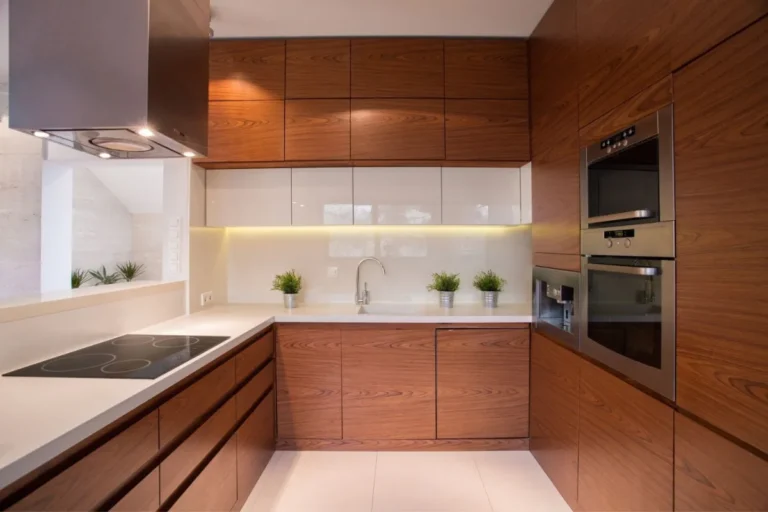 Modern wood-finish IKEA kitchen cabinets with built-in appliances and under-cabinet lighting, illustrating the hidden costs of IKEA kitchen cabinets