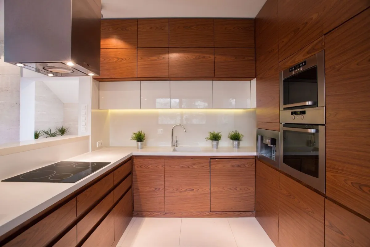 Modern wood-finish IKEA kitchen cabinets with built-in appliances and under-cabinet lighting, illustrating the hidden costs of IKEA kitchen cabinets