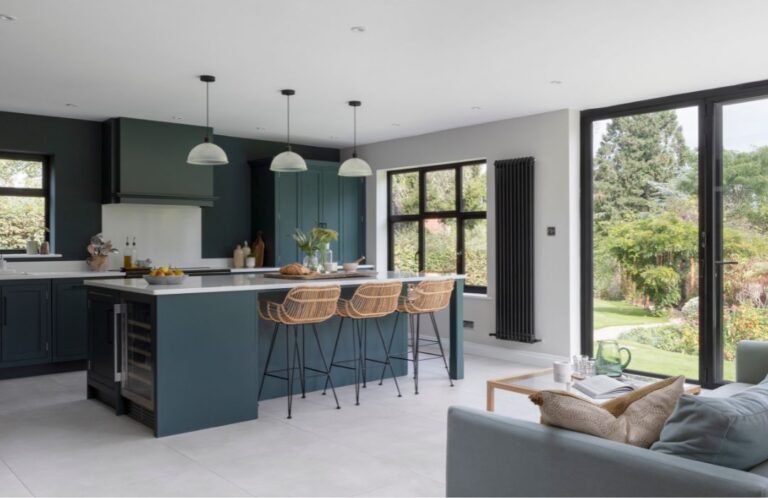 Modern open-concept kitchen with family friendly kitchen cabinets, a large island, deep blue cabinetry, pendant lighting, and bright garden views