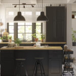 Black IKEA kitchen cabinets styled to look custom with a wood island countertop, full-height cabinetry, pendant lighting, and a bright, upscale layout.
