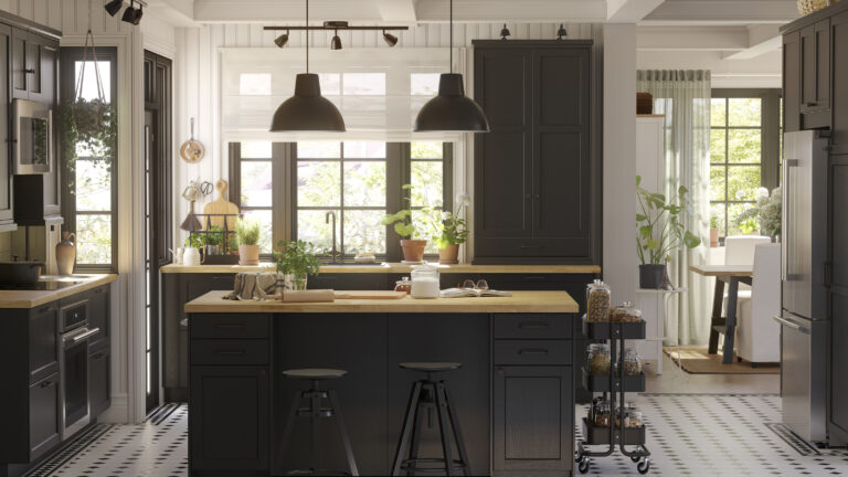 Black IKEA kitchen cabinets styled to look custom with a wood island countertop, full-height cabinetry, pendant lighting, and a bright, upscale layout.