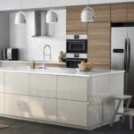 Modern kitchen cabinets with a sleek white island, warm wood wall cabinets, and built-in stainless steel appliances in a contemporary kitchen.