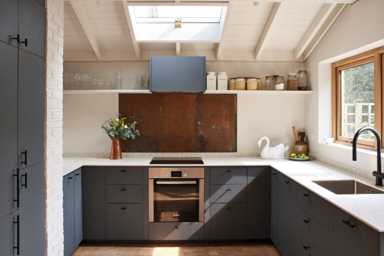 Modern dark gray kitchen design showing IKEA kitchen cabinet colors for small kitchens with white countertops, skylight, and natural light