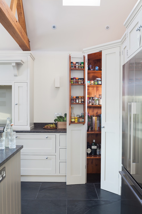 Farmhouse kitchen layout with pantry cabinet storage near refrigerator and cabinet run